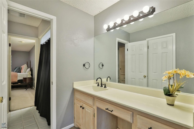 bathroom featuring vanity, a textured ceiling, and tile patterned flooring