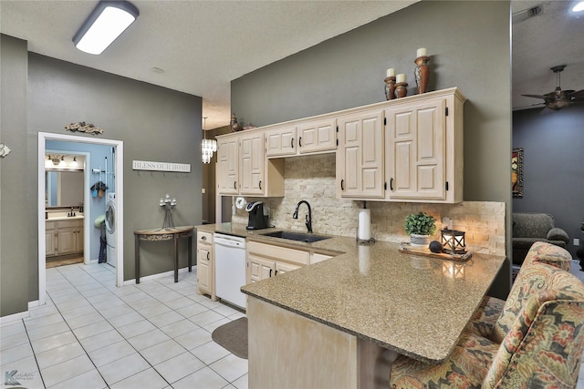 kitchen with kitchen peninsula, tasteful backsplash, ceiling fan, sink, and dishwasher