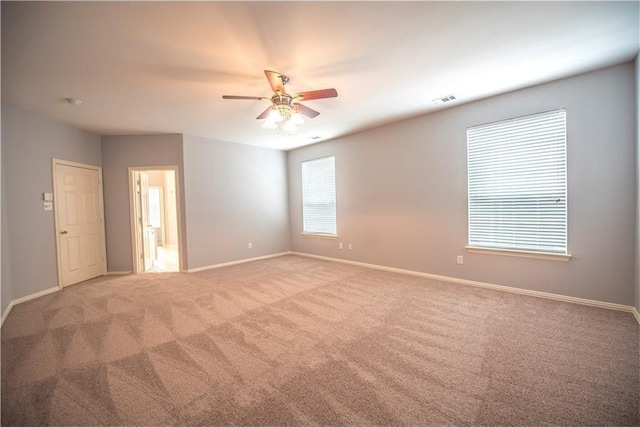 carpeted spare room featuring ceiling fan