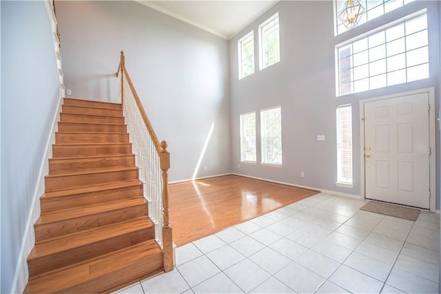 6321 Bear Run Rd, The Colony, TX 75056 - entryway with stairs, light tile patterned flooring, a towering ceiling, baseboards, and ornamental molding