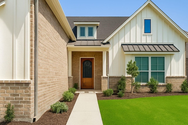 property entrance with a standing seam roof, board and batten siding, metal roof, and brick siding