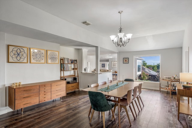 dining space featuring dark wood-type flooring, vaulted ceiling, and a notable chandelier