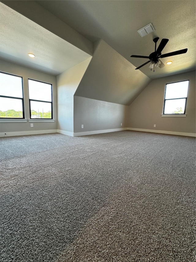 bonus room with ceiling fan, a textured ceiling, lofted ceiling, and carpet flooring