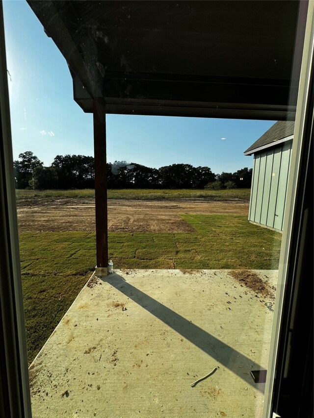 view of yard featuring a rural view and a patio