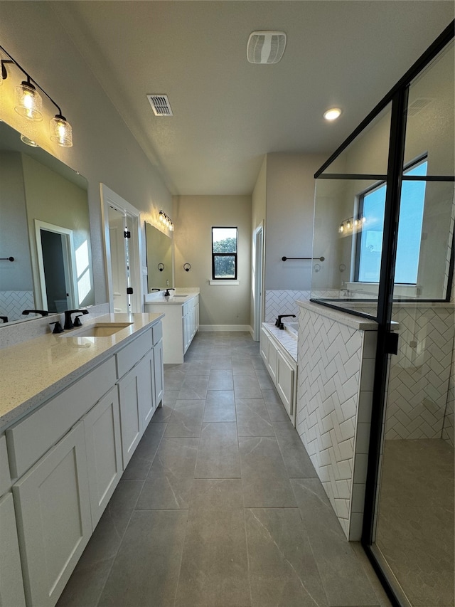 bathroom with independent shower and bath, vanity, and tile patterned floors