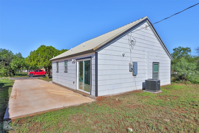 view of property exterior with a patio, cooling unit, and a yard