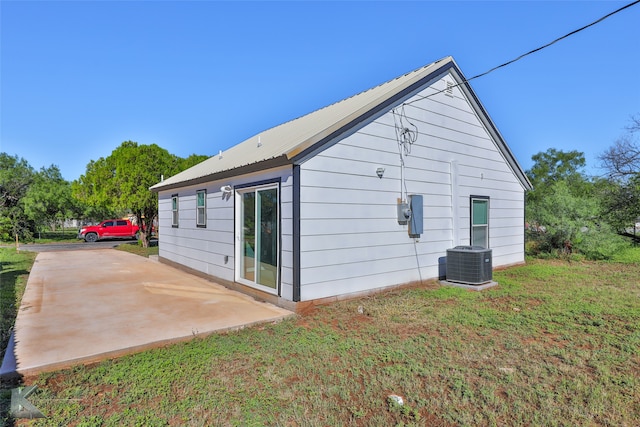 view of home's exterior with a lawn, central AC unit, and a patio area