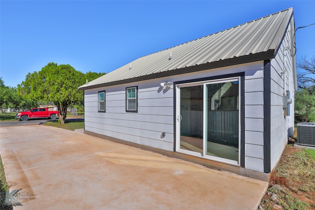 back of property with cooling unit and a patio area