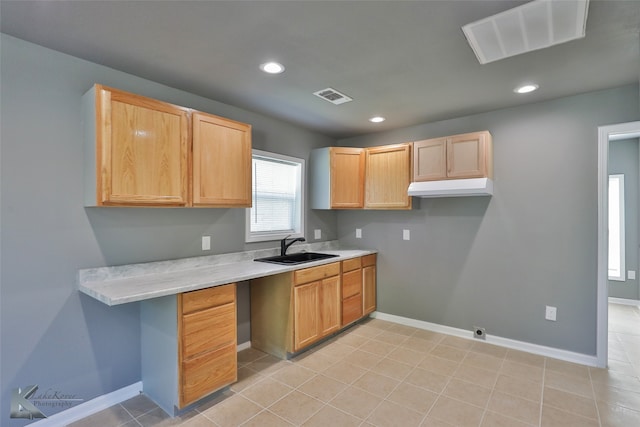 kitchen featuring light brown cabinets, light tile patterned floors, and sink