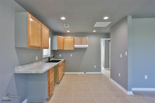 kitchen featuring light brown cabinets, light tile patterned flooring, and sink