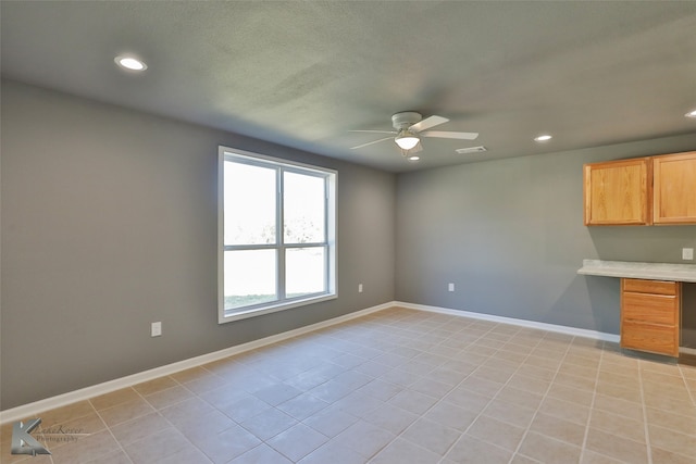 interior space with built in desk and ceiling fan