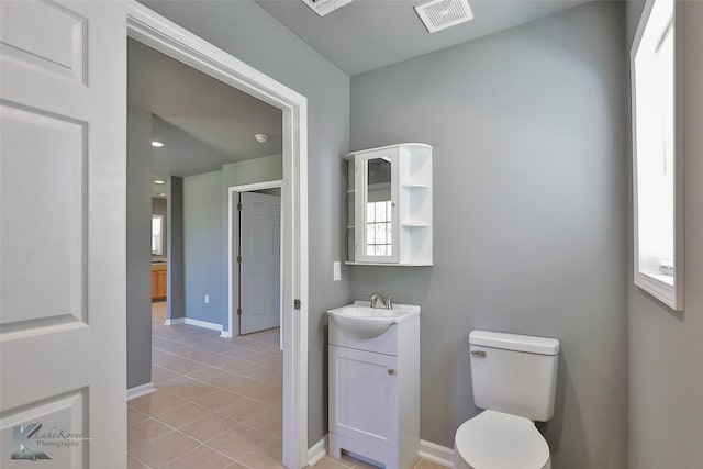 bathroom featuring tile patterned flooring, vanity, and toilet