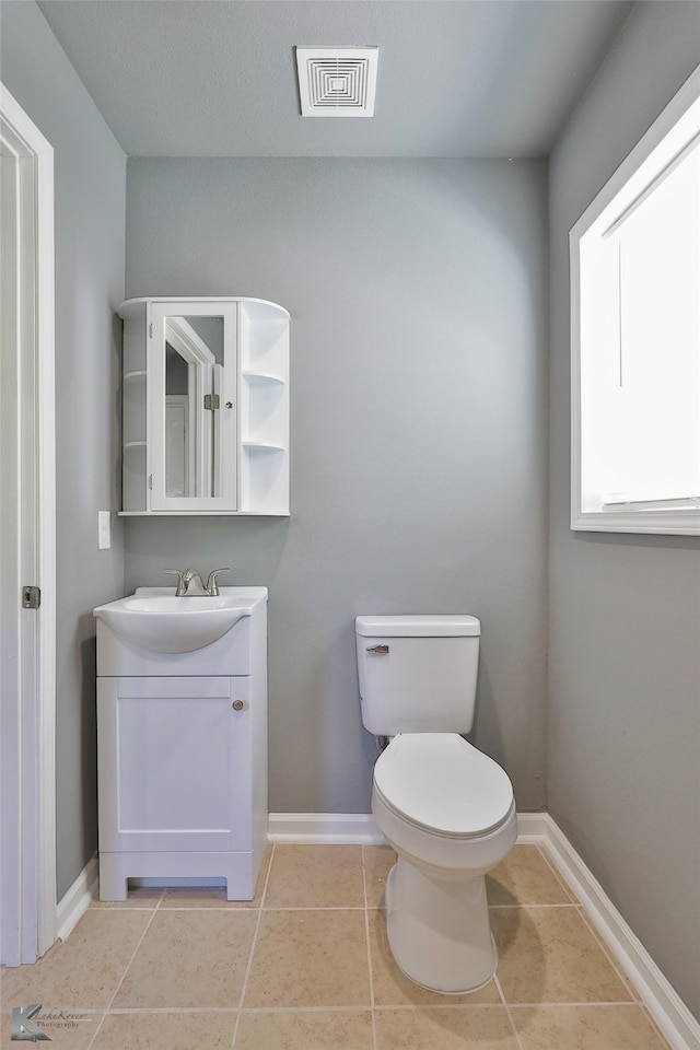 bathroom with vanity, toilet, and tile patterned floors