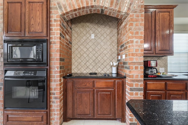 kitchen featuring dark stone countertops, light tile patterned floors, tasteful backsplash, and black appliances