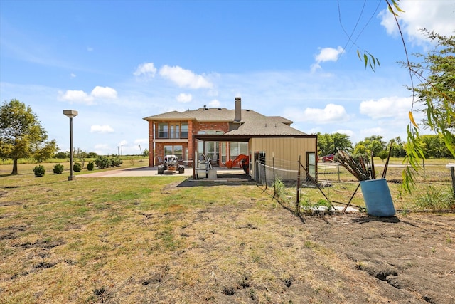 back of property with a yard and a patio