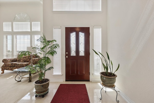 entryway with a high ceiling and light tile patterned floors