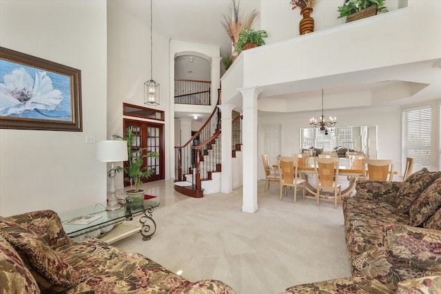 carpeted living room featuring a raised ceiling, decorative columns, a towering ceiling, and a chandelier