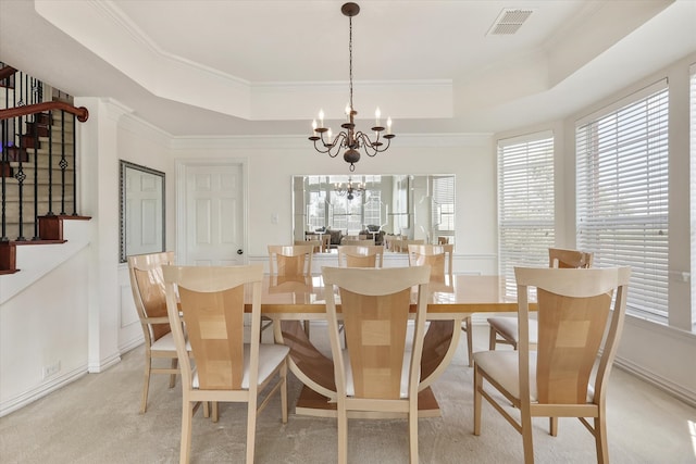 dining space featuring a notable chandelier, a tray ceiling, ornamental molding, and a healthy amount of sunlight