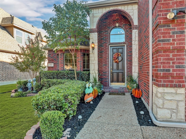 entrance to property featuring a lawn