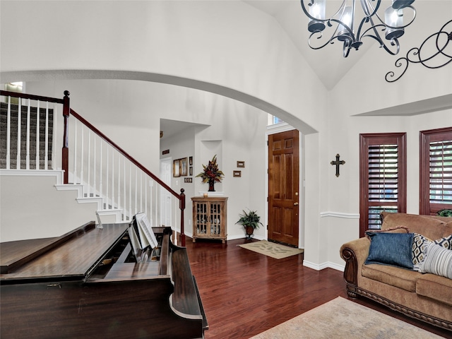 entrance foyer featuring dark hardwood / wood-style flooring, high vaulted ceiling, and a notable chandelier