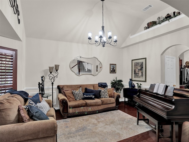 living room featuring an inviting chandelier, high vaulted ceiling, and dark wood-type flooring