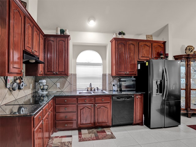 kitchen with dishwasher, sink, decorative backsplash, dark stone countertops, and stainless steel fridge