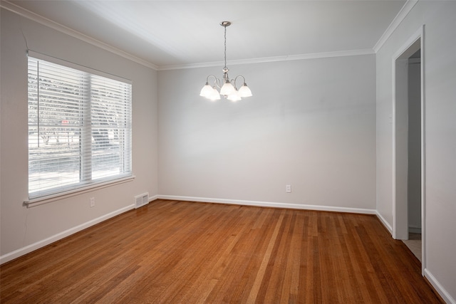 empty room with hardwood / wood-style flooring, a notable chandelier, and ornamental molding