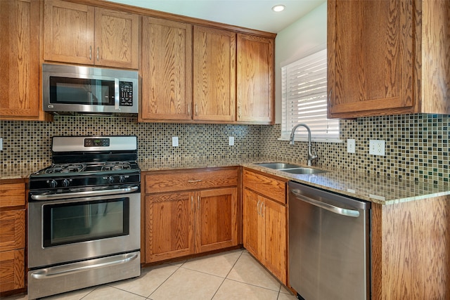 kitchen featuring appliances with stainless steel finishes, sink, tasteful backsplash, and light tile patterned floors