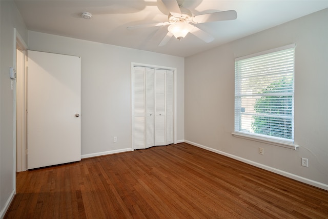 unfurnished bedroom featuring hardwood / wood-style floors, ceiling fan, and a closet