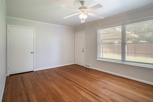 spare room featuring ceiling fan, wood-type flooring, and crown molding