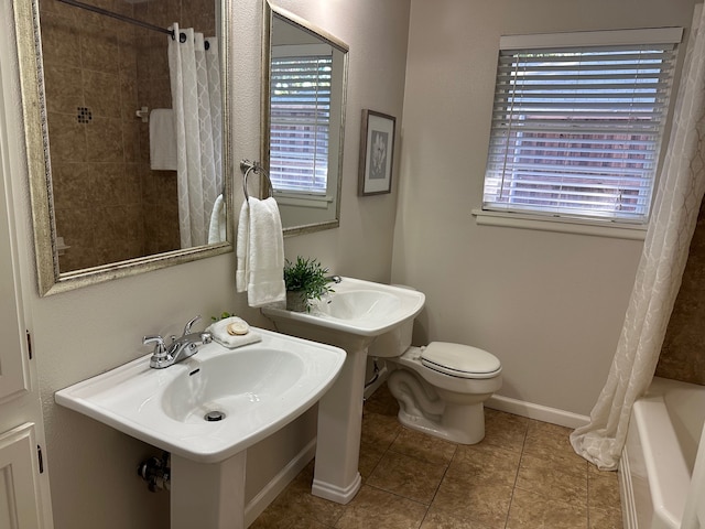 bathroom featuring toilet, double sink, shower / bath combination with curtain, and tile patterned flooring