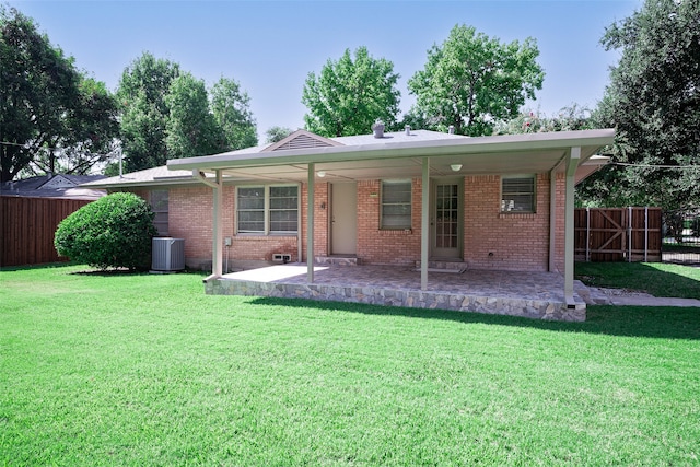 rear view of property featuring central air condition unit, a yard, and a patio area