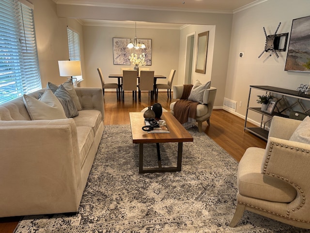 living room with dark hardwood / wood-style flooring, a notable chandelier, and ornamental molding