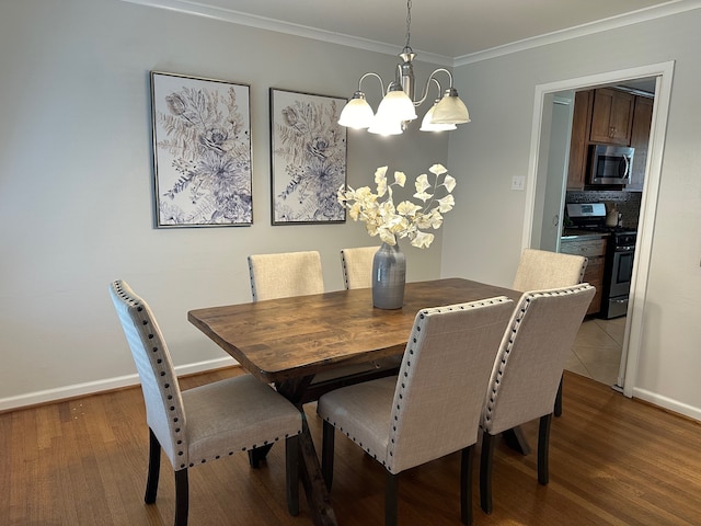 dining area with hardwood / wood-style floors, crown molding, and an inviting chandelier