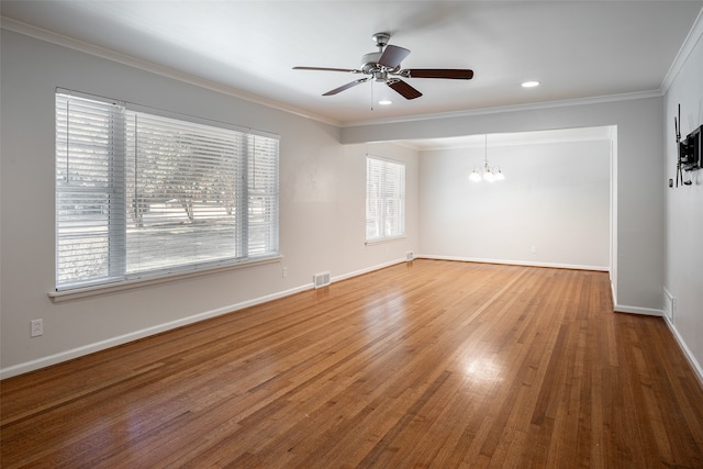 unfurnished room with hardwood / wood-style floors, ceiling fan with notable chandelier, and crown molding