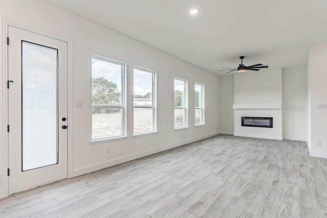 unfurnished living room with light hardwood / wood-style flooring and ceiling fan