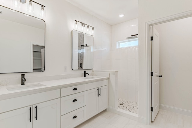 bathroom featuring a tile shower and vanity