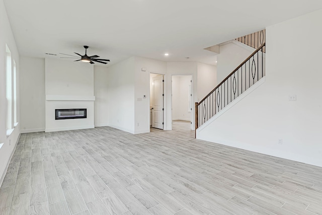 unfurnished living room with light wood-type flooring and ceiling fan