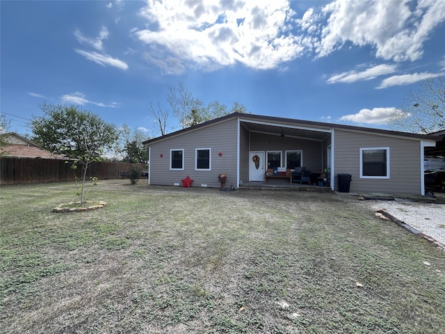 back of house featuring a lawn and a patio