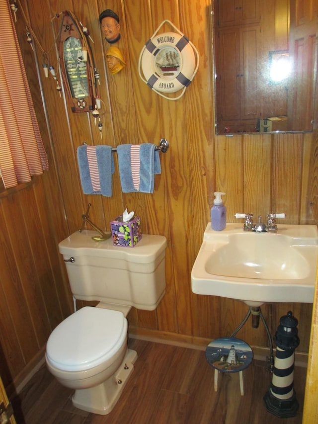 401 Craig St, Hillsboro, TX 76645 - half bathroom with toilet, wood finished floors, a sink, wooden walls, and baseboards