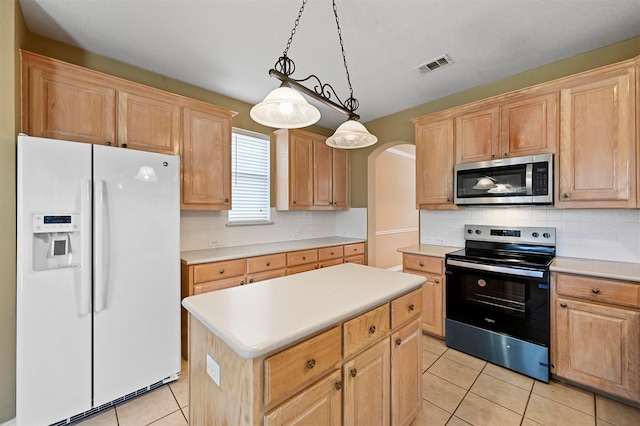 kitchen featuring appliances with stainless steel finishes, a kitchen island, light tile patterned floors, and decorative light fixtures