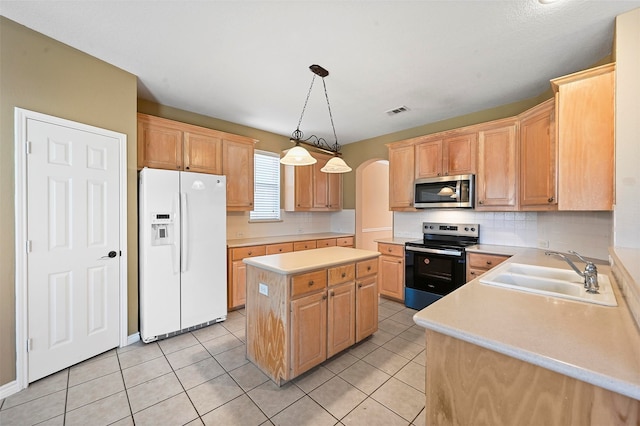 kitchen with hanging light fixtures, light tile patterned floors, sink, a kitchen island, and appliances with stainless steel finishes