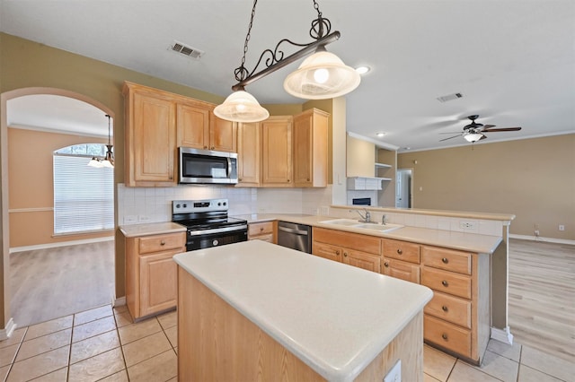 kitchen with ceiling fan with notable chandelier, appliances with stainless steel finishes, and light brown cabinetry