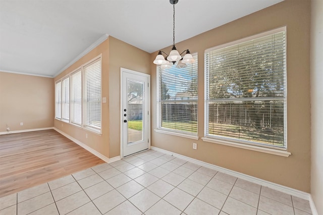 unfurnished dining area with an inviting chandelier, light wood-type flooring, and ornamental molding