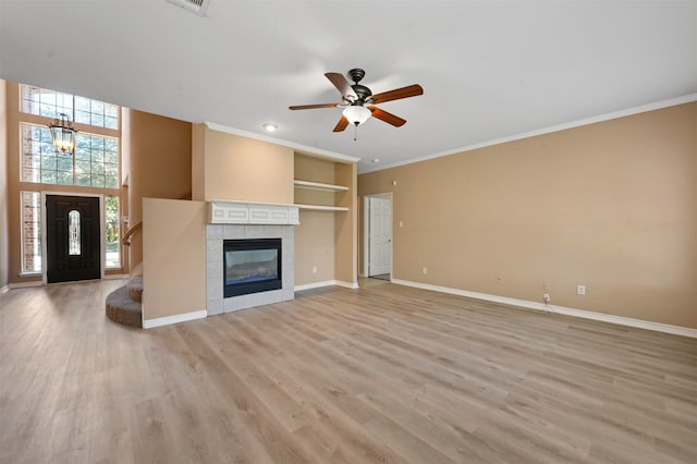 unfurnished living room featuring ornamental molding, ceiling fan with notable chandelier, light hardwood / wood-style floors, and a tile fireplace