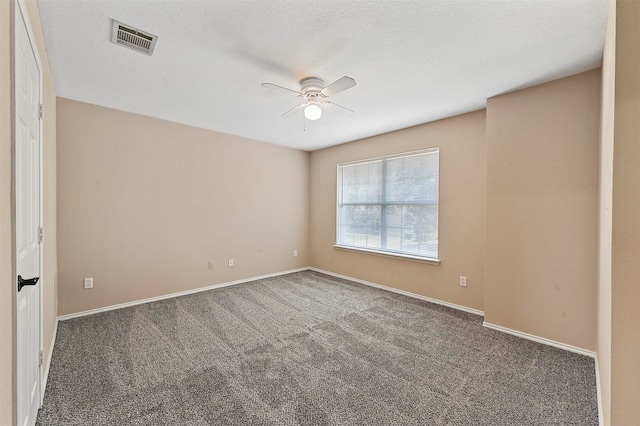 spare room with dark carpet, ceiling fan, and a textured ceiling