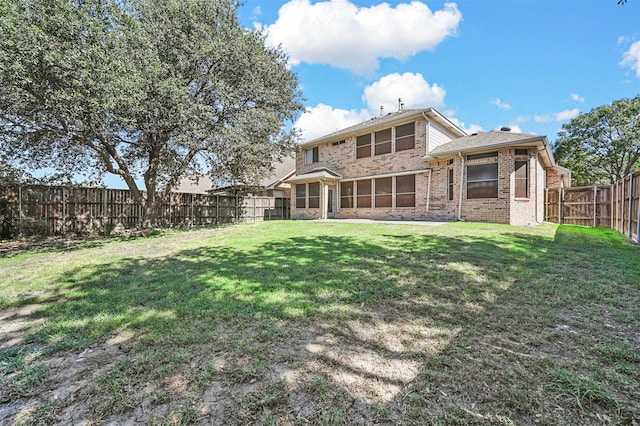 rear view of house featuring a yard