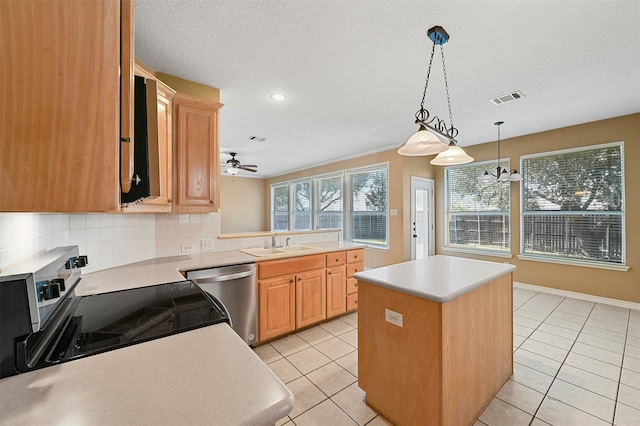 kitchen with ceiling fan, sink, tasteful backsplash, a kitchen island, and stainless steel appliances