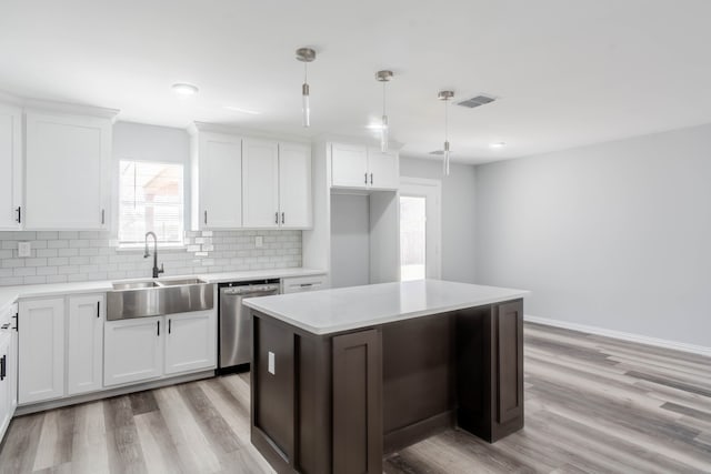 kitchen with dishwasher, white cabinetry, hanging light fixtures, and a kitchen island