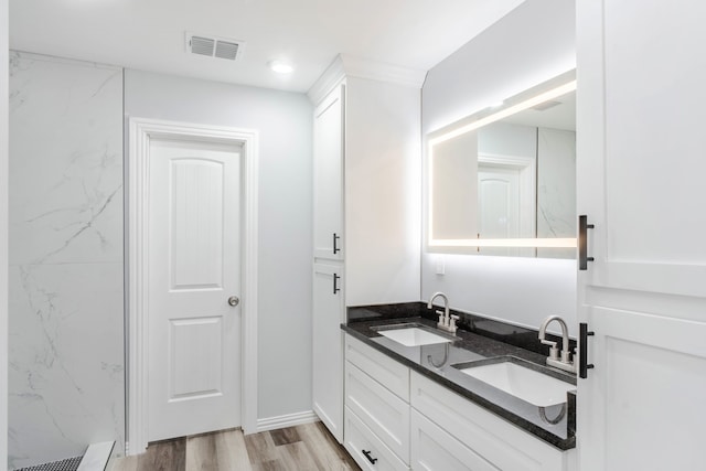 bathroom featuring a tile shower, vanity, and hardwood / wood-style flooring